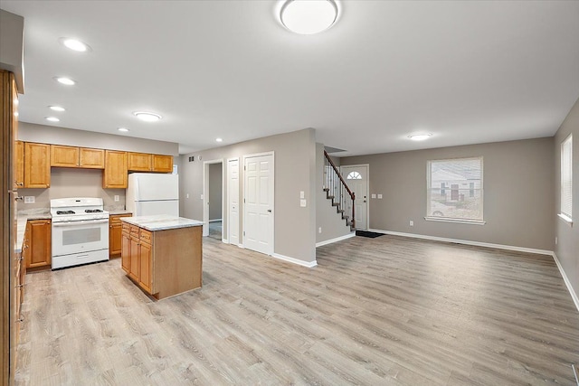 kitchen featuring a kitchen island, white appliances, and light hardwood / wood-style flooring