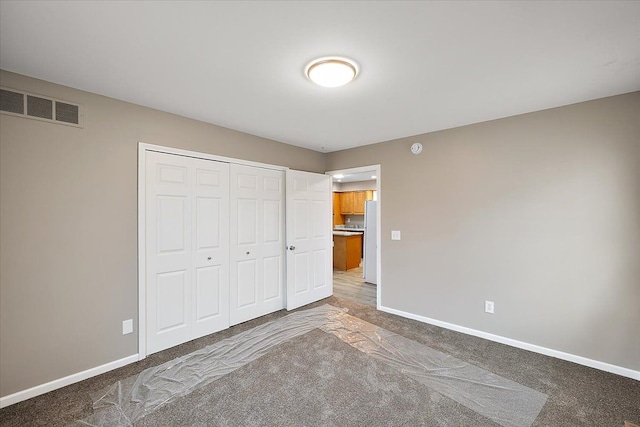 unfurnished bedroom featuring carpet flooring and a closet