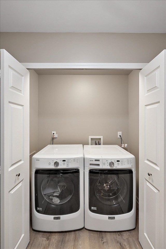 laundry room with light hardwood / wood-style flooring and washer and dryer