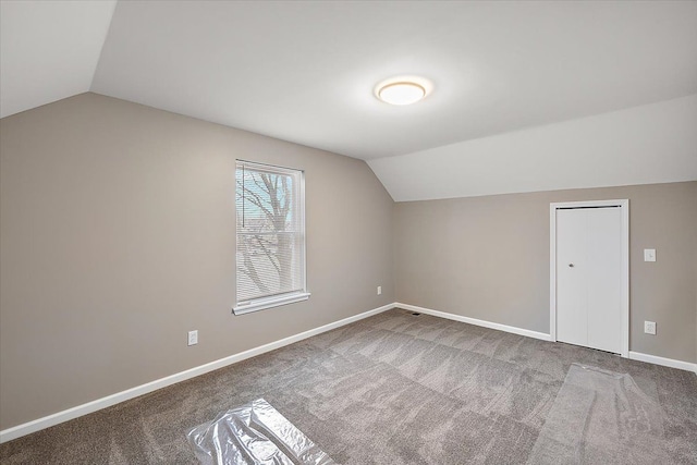 bonus room with lofted ceiling and carpet flooring