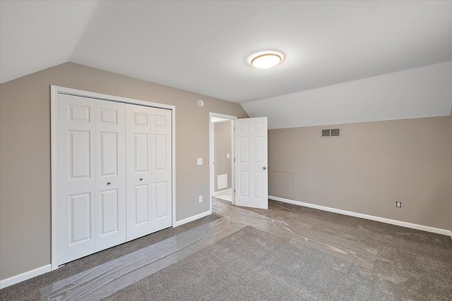 unfurnished bedroom featuring lofted ceiling, carpet floors, and a closet