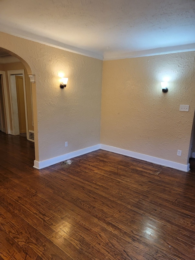 empty room featuring crown molding and dark hardwood / wood-style floors