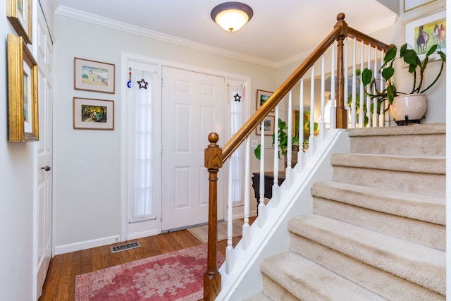 foyer with dark wood-type flooring and ornamental molding