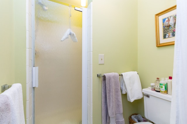 bathroom with toilet and a shower with shower door