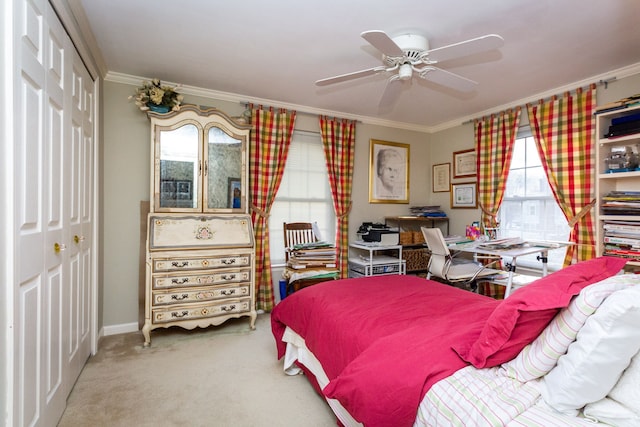 carpeted bedroom featuring ornamental molding, ceiling fan, and a closet