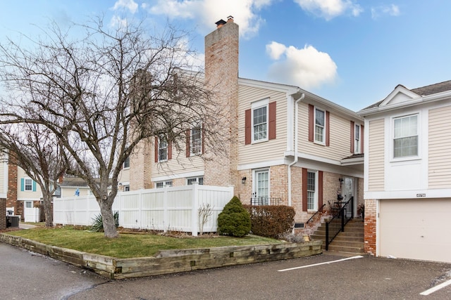 view of front of home with a garage and central air condition unit