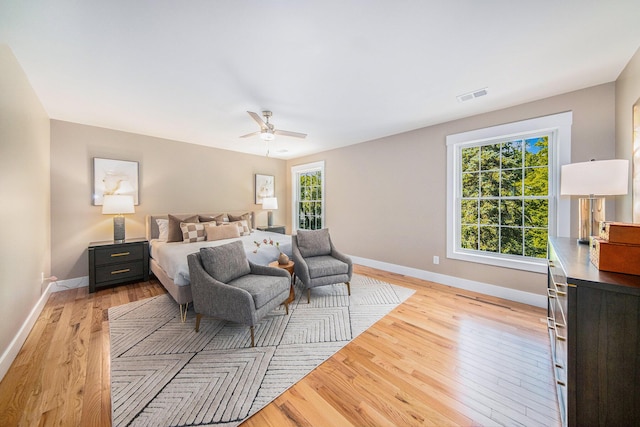 bedroom with multiple windows, light hardwood / wood-style flooring, and ceiling fan