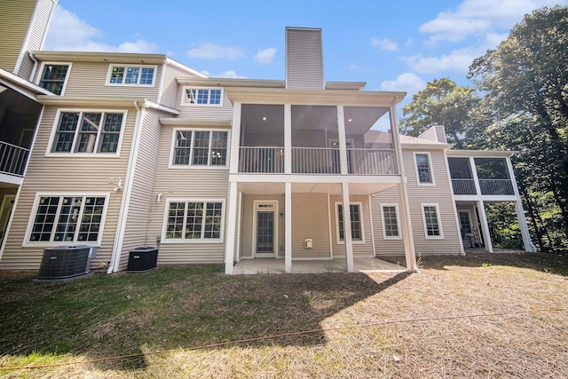 back of property featuring a yard, a sunroom, a patio, and central air condition unit