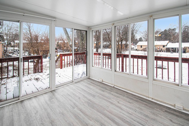 unfurnished sunroom featuring plenty of natural light and vaulted ceiling