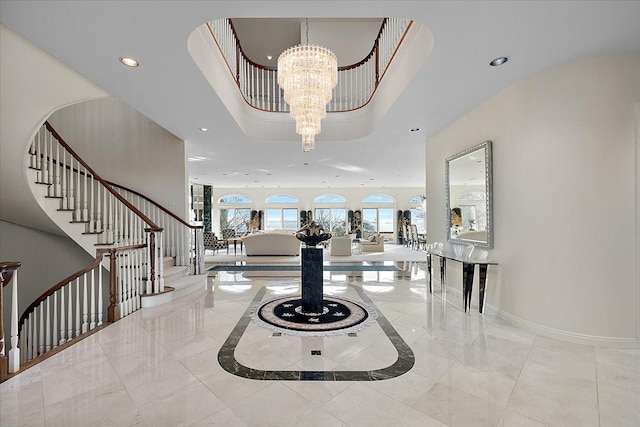 entryway with a tray ceiling and a notable chandelier