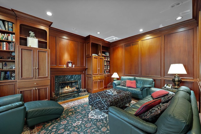 living room featuring ornamental molding, built in shelves, and a high end fireplace