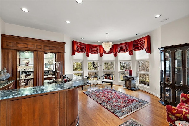 interior space with a notable chandelier, sink, and light hardwood / wood-style floors