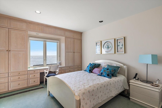 bedroom featuring carpet, built in desk, and a water view