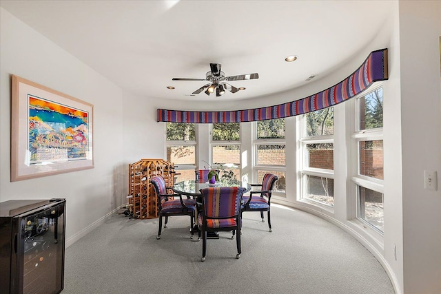 dining area featuring wine cooler, ceiling fan, and carpet floors