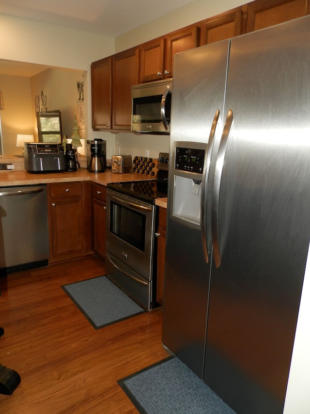 kitchen with stainless steel appliances and dark hardwood / wood-style flooring