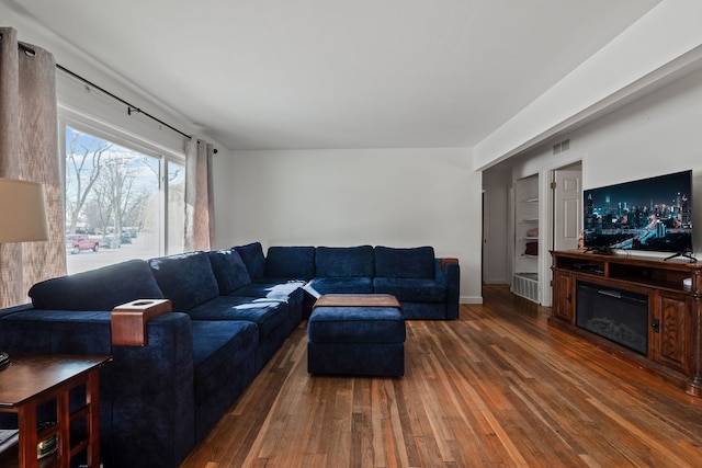 living room featuring dark hardwood / wood-style flooring and built in shelves