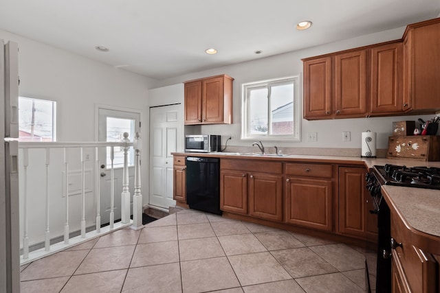 kitchen featuring plenty of natural light, sink, light tile patterned floors, and black appliances