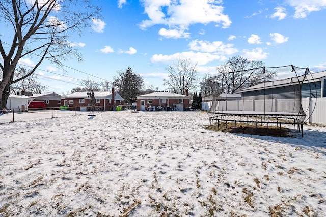 snowy yard featuring a trampoline