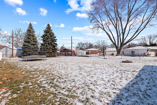 yard layered in snow featuring a trampoline