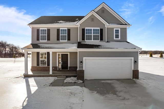 view of front of property featuring a porch, brick siding, driveway, and an attached garage