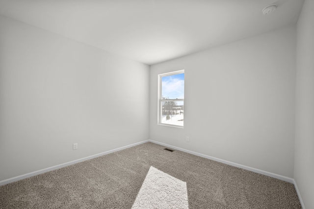 carpeted spare room with baseboards and visible vents