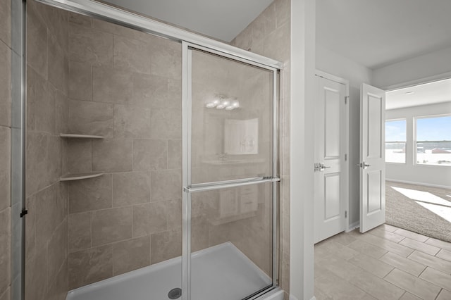 full bathroom featuring a shower stall and baseboards