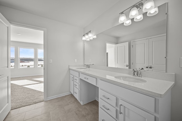 full bath featuring double vanity, baseboards, a sink, and tile patterned floors