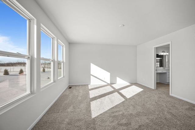 carpeted spare room featuring visible vents and baseboards