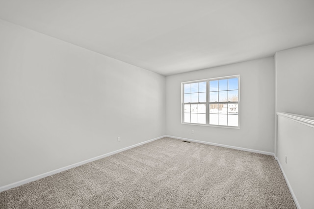 carpeted spare room featuring visible vents and baseboards