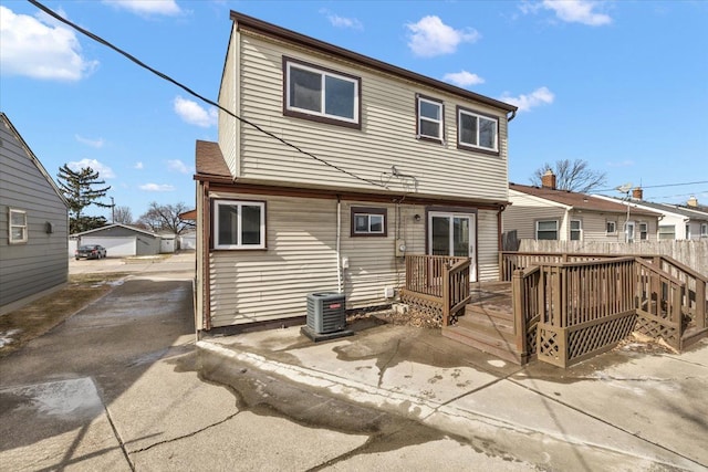 back of house featuring cooling unit and a wooden deck