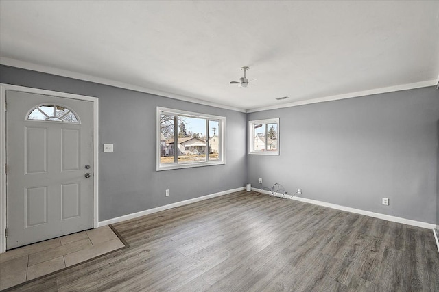 entryway with ceiling fan, wood-type flooring, and ornamental molding