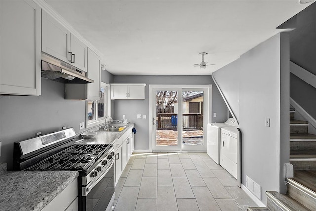 kitchen featuring stainless steel gas range, sink, white cabinetry, separate washer and dryer, and ceiling fan