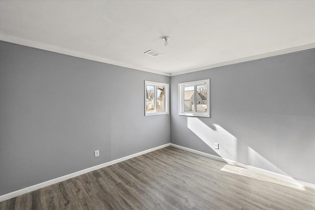 spare room with hardwood / wood-style flooring and crown molding