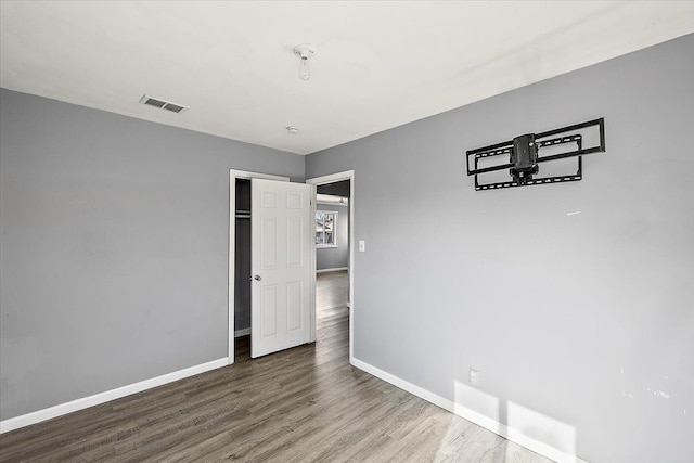 unfurnished bedroom featuring wood-type flooring and a closet