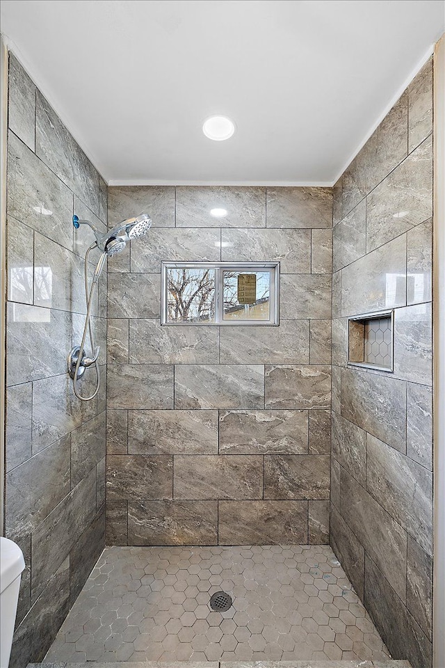 bathroom with tiled shower and toilet