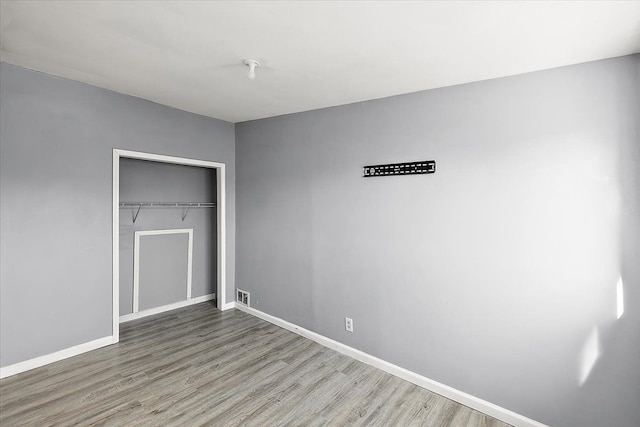 unfurnished bedroom with hardwood / wood-style flooring and a closet