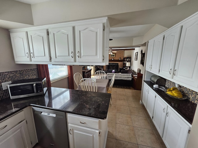 kitchen with white cabinetry, tasteful backsplash, light tile patterned floors, appliances with stainless steel finishes, and kitchen peninsula