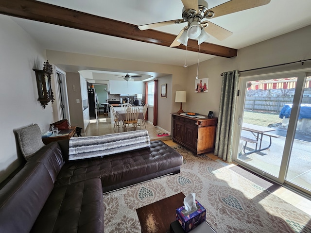 living room featuring ceiling fan and beamed ceiling