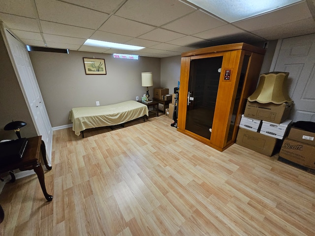 bedroom featuring a paneled ceiling and light wood-type flooring