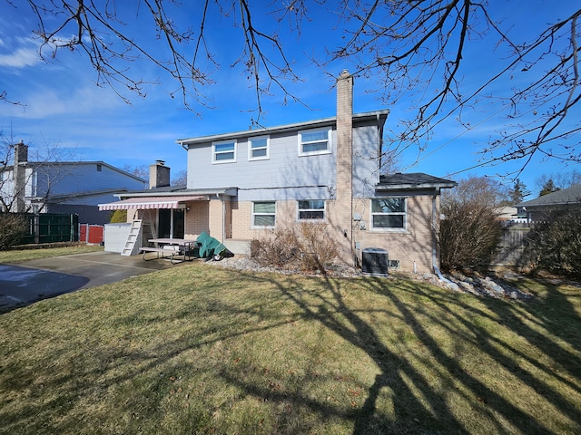 back of property with cooling unit and a lawn