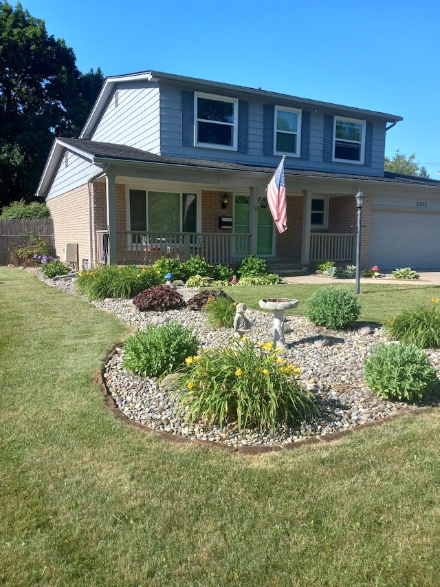 view of front of house with a garage, a front lawn, and a porch