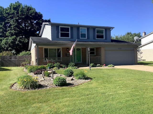 view of front of house featuring a garage, covered porch, and a front yard