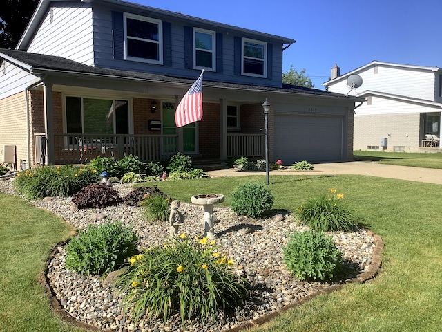 view of front of property with a porch, a garage, and a front yard