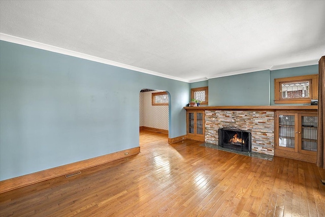 unfurnished living room featuring hardwood / wood-style flooring, crown molding, and a textured ceiling