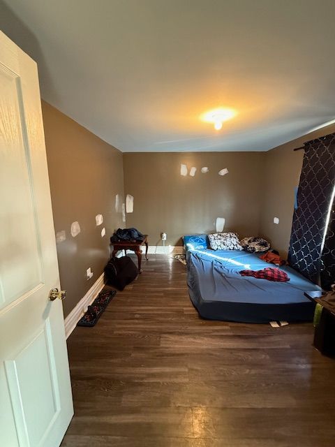 bedroom with dark hardwood / wood-style flooring and vaulted ceiling