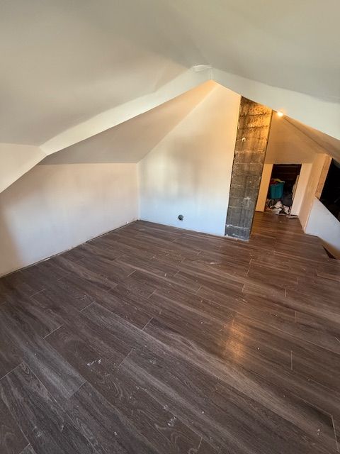 bonus room featuring lofted ceiling and dark hardwood / wood-style flooring