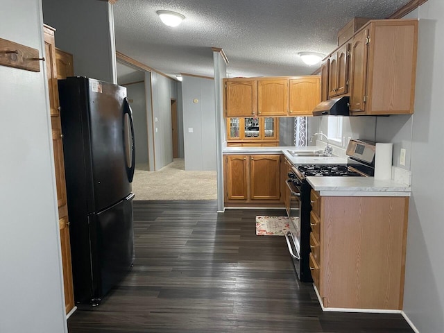 kitchen with sink, dark wood-type flooring, black refrigerator, stainless steel range with gas stovetop, and a textured ceiling