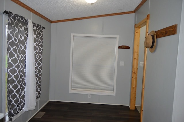 unfurnished room featuring crown molding, dark wood-type flooring, and a textured ceiling