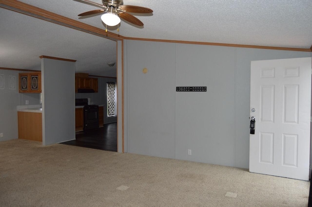 carpeted spare room featuring crown molding, ceiling fan, and a textured ceiling