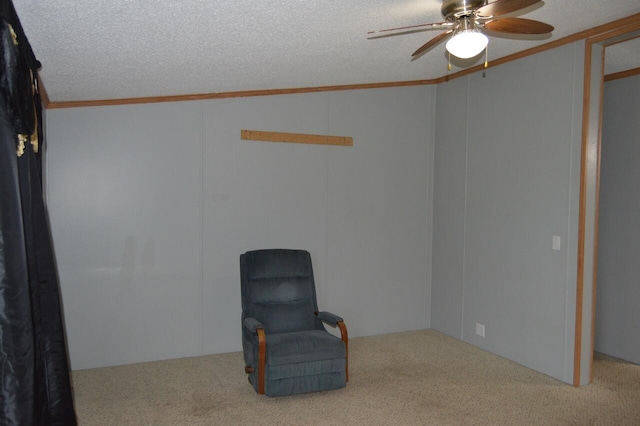 sitting room featuring ceiling fan, carpet floors, and a textured ceiling